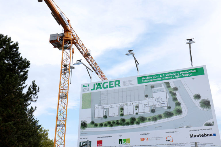 Kran und Baustellenschild beim Neubau der Jäger Group